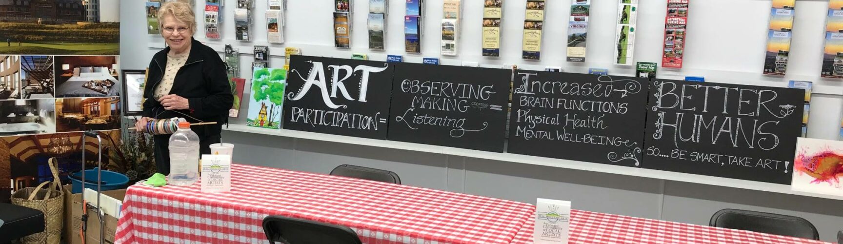 Woman at red checkered table in front of arts and crafts display